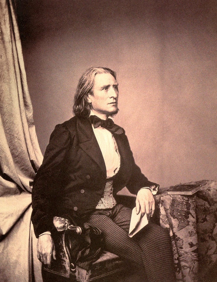 Famous pianists: Liszt. Old timey sepia tone photo of man with shoulder length hair in suit and bowtie.